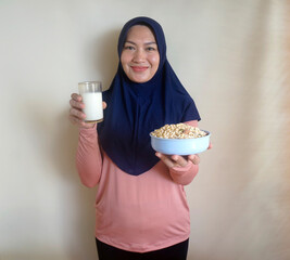 Selective Focus Of Asian Woman Offering A Glass Of Milk And A Bowl Of Muesli. Selective Focus On...