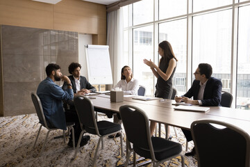 Group brainstorming. Focused multiracial businesspeople listen to businesswoman team leader setting startup task problem. Office staff engaged together in discussion think on strategy manager question
