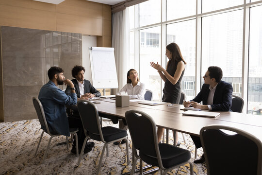Group brainstorming. Focused multiracial businesspeople listen to businesswoman team leader setting startup task problem. Office staff engaged together in discussion think on strategy manager question