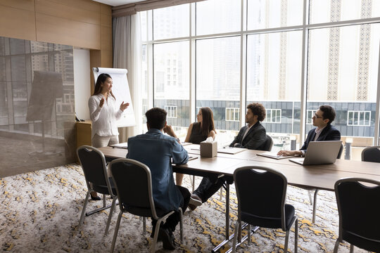 Professional development. Confident happy Asian lady businesswoman trainer coach expert talk lead corporate education event coaching program presentation for multiracial group trainees at boardroom