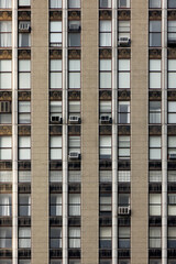 Urban high-rise building with symmetrical windows and air conditioners. Repetition and texture concept.  
