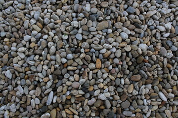 Smooth round pebbles texture background. Pebble sea beach close-up, dark wet pebble and gray dry pebble. natural gravel, texture from gravel. Gravel texture. Pebble stone background. Granite gravel
