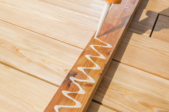 Wood Glue Applied in a Zigzag Pattern on a Wooden Plank for Construction or Crafting Project
