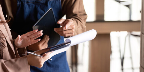 Collaborative Business Discussion. Two professionals engaging in a productive meeting over a tablet and documents.