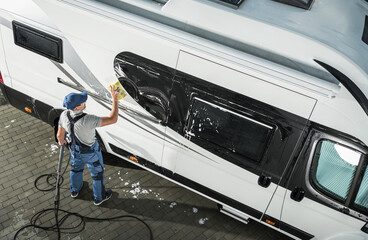 Professional Cleaning of a Recreational Vehicle Takes Place in a Driveway During Daylight Hours