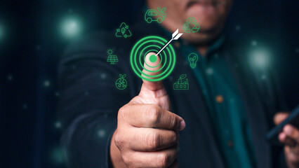 Man holding thumbs up to target surrounded by green energy and sustainability icons on green background. Carbon footprint. Green energy and sustainability concept