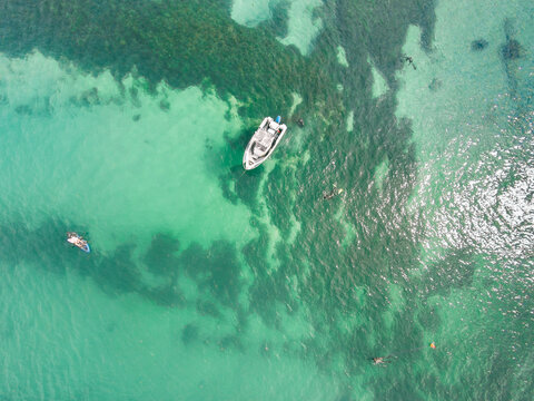 Looking down on boat and people in a calm blue ocean