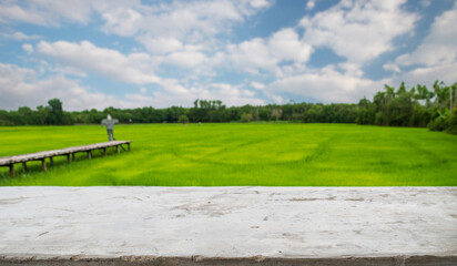 empty cement old table on blur rice field and cloud background, for your product placement or montage with focus to the table top in the foreground. blank shelf, shelves with copy space