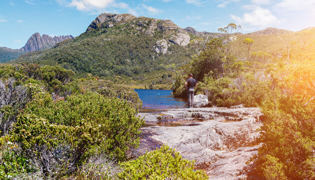 a man pauses at a viewpoint whilst hiking in Tasmania