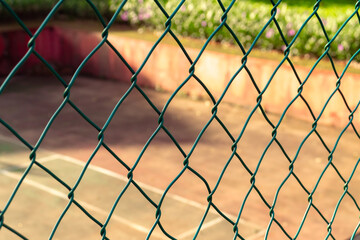 Fences with tennis court in the background on a sunny day. After edits. 