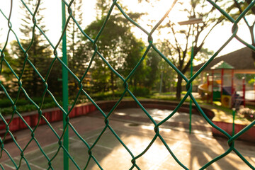 Fences with tennis court in the background on a sunny day. After edits. 