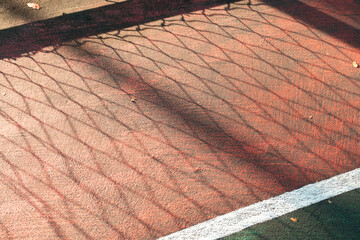 Sport concept. Basketball court on public park with shadow of fences. After edits.