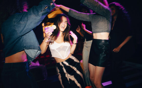 Friends having fun and dancing at a club with vibrant nightlife vibes