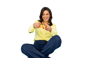 Young woman sitting with crossed legs holding a controller and playing videogames, isolated on transparent background