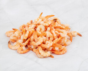 Pile of cooked shrimp on white marble background ready for preparation