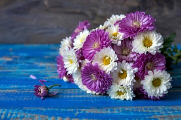 side view of violet and white color chrysanthemum flowers bouquet isolated on blue wooden background