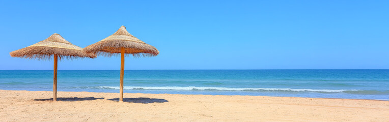 Straw Parasols on Quiet Tropical Beach with Azure Blue Sea View