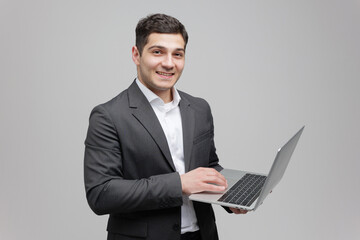 Confident young professional showcasing his skills while using a laptop in a minimalist studio setting