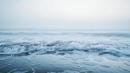 Calm and foggy morning at the sea with gentle waves and a soft breeze, creating a peaceful and reflective ambiance