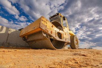 Steamroller performing leveling work on a road under construction