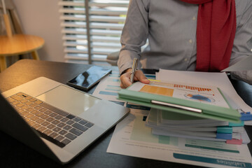 a muslim company employee works in a large financial organization, a muslim female entrepreneur is reviewing her company's financial documents, marketing, accountant, hijab, islam