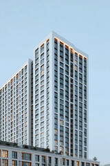 Modern high-rise residential building with minimalist architecture and clear blue sky
