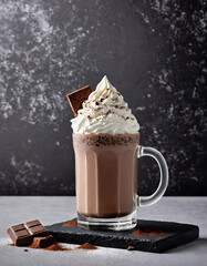 Thick Chocolate Milkshake in Frosted Glass with Whipped Cream, Cocoa Powder, and Chocolate Shavings on Dark Background