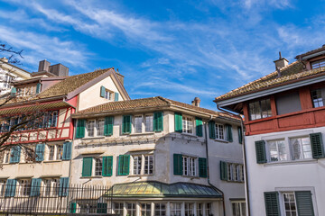 Obraz premium Historic Zurich Architecture: Traditional Houses with Green Shutters, Blue Sky.Charming Old Town Zurich: Green Shutters, Tiled Roofs, Sunny Sky.Classic Zurich Facades