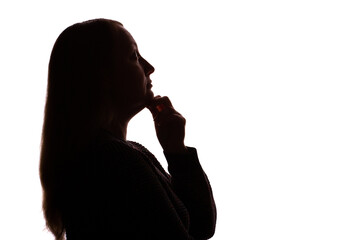 Silhouette of young woman touching her chin thoughtfully, white background