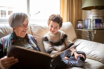 Grandmother and grandchild sharing precious moments looking at photo album