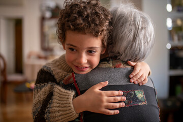 Grandchild hugging grandmother at home showing love and affection