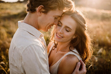 Fototapeta premium Man and woman in the middle of a field on a summer evening.