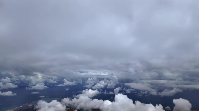 an immersive pilot view from an airplane cockpit while flying between layers of white cottony clouds over Valencia City and Harbor.