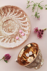 Flat lay of wellness supplements and colorful medicinal flowers like chamomile and yarrow on neutral backgrounds. Pills arranged in spoons and aesthetic compositions