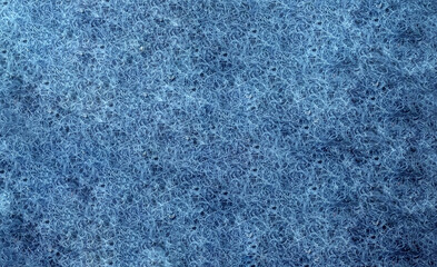 Texture of a blue synthetic scrubbing pad or abrasive sponge material. The fibrous structure..