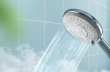 Shower head and water stream in blue bathroom