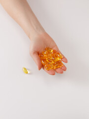 Woman's palm with gelatin capsules on it on white background. Space for text