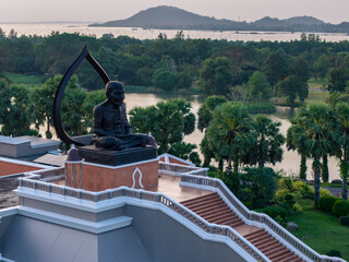 Luang Pu Thuat statue (Wat Chang Hai Rasburanaram) at Songkhla, Thailand, at sunset. The Thai sign...