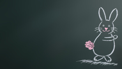 Cute bunny drawing on chalkboard with pink chalk and copy space