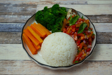 A portion of pescatarian food with a menu of boiled carrots and broccoli, fried fish in Dabu Dabu sauce.