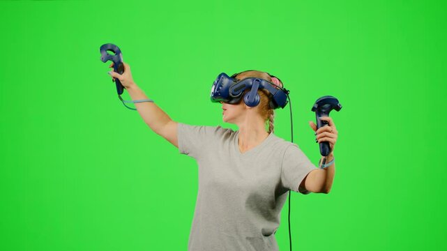 The girl wearing VR headset flying in virtual reality in video game. The woman gaming in virtual reality on chroma key green screen flying in space. Concept fly sport game VR headset virtual reality