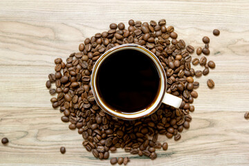 Coffee mug on coffee beans background in center. Top view, copy space for text.