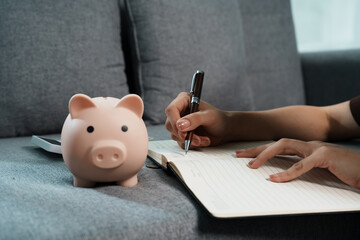 Person inserting coin into piggy bank, symbolizing saving money, financial planning, investment, budgeting, and securing future wealth and economic stability.