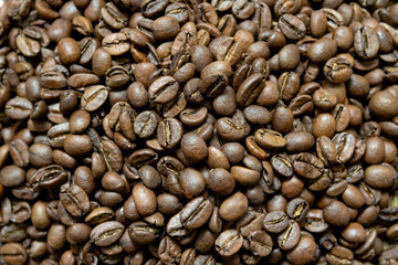 Top view background of aromatic brown coffee beans scattered on surface.