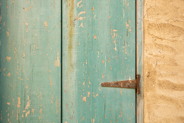 old teal wooden door with rustic hinges, wooden door in stone wall 