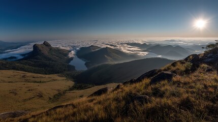 Fototapeta premium Sunlit distant mountains under green-blue sky with fog covering from base to peak. Panoramic wide-angle view in high-definition, natural lighting, warm tones, tranquil and magnificent scenery.