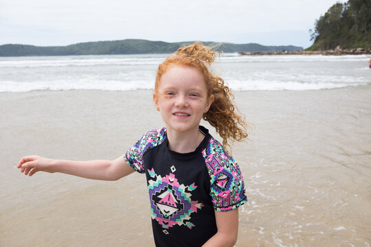Young windswept girl smiling at the beach