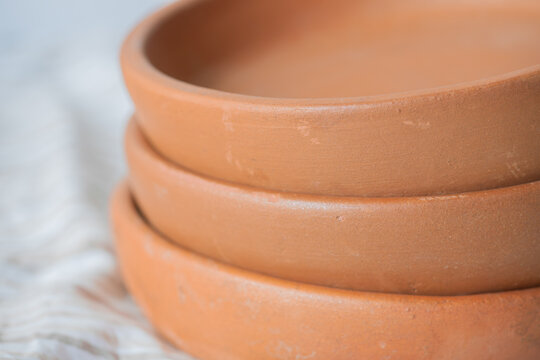Set of three georgian frying pan ketsi. Ketsi, georgian traditional handmade unglazed ceramic cookware, clay round frying pan, dish, plate, pot, all in one, close-up, high resolution.