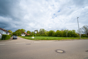 Street corner view with overcast sky, greenery, and adjacent buildings. Speed limit sign visible...