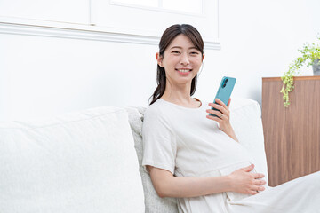 携帯を持つ妊婦